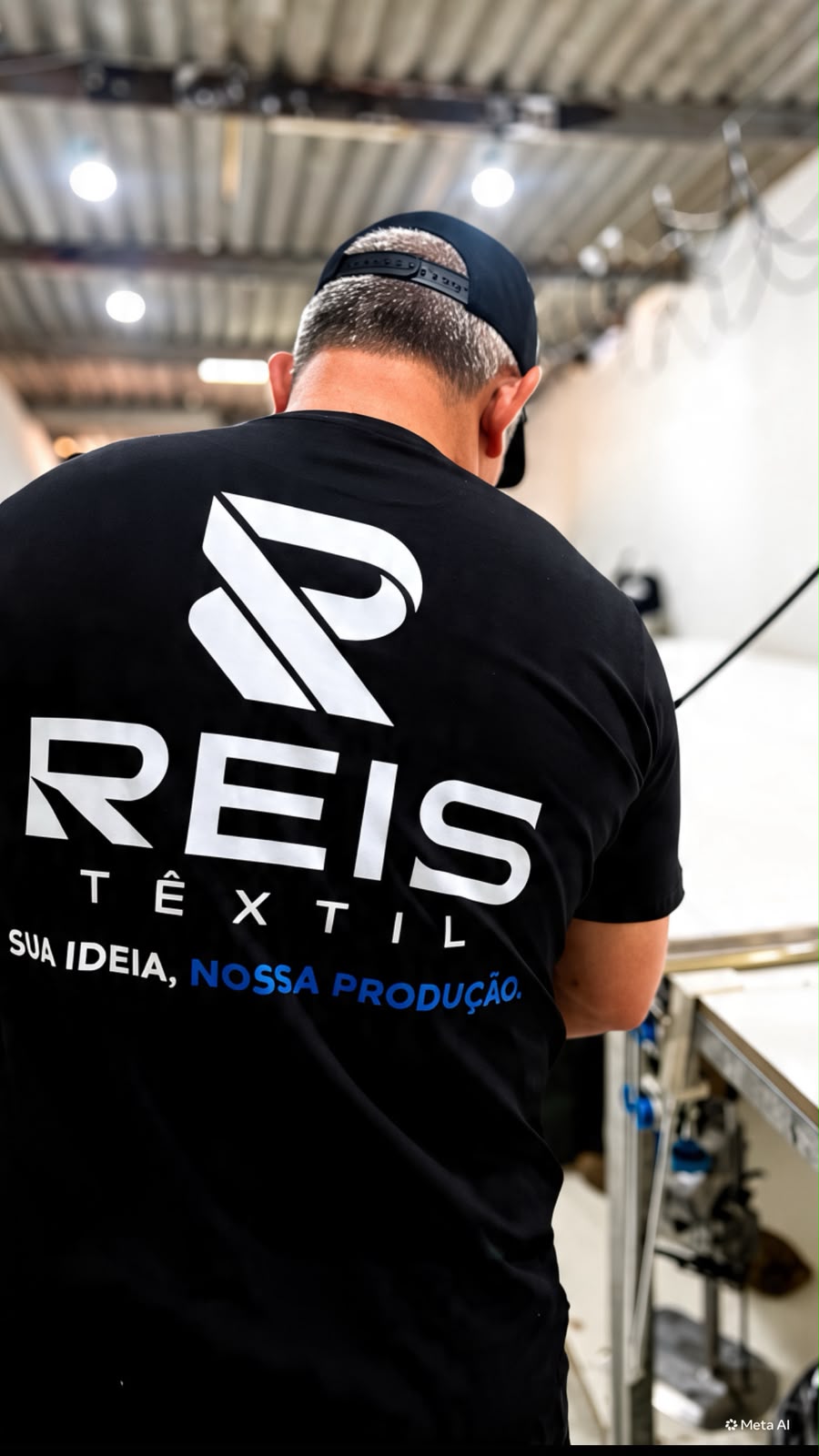 Integrante da Reis Têxtil usando uma camiseta da marca na área de produção